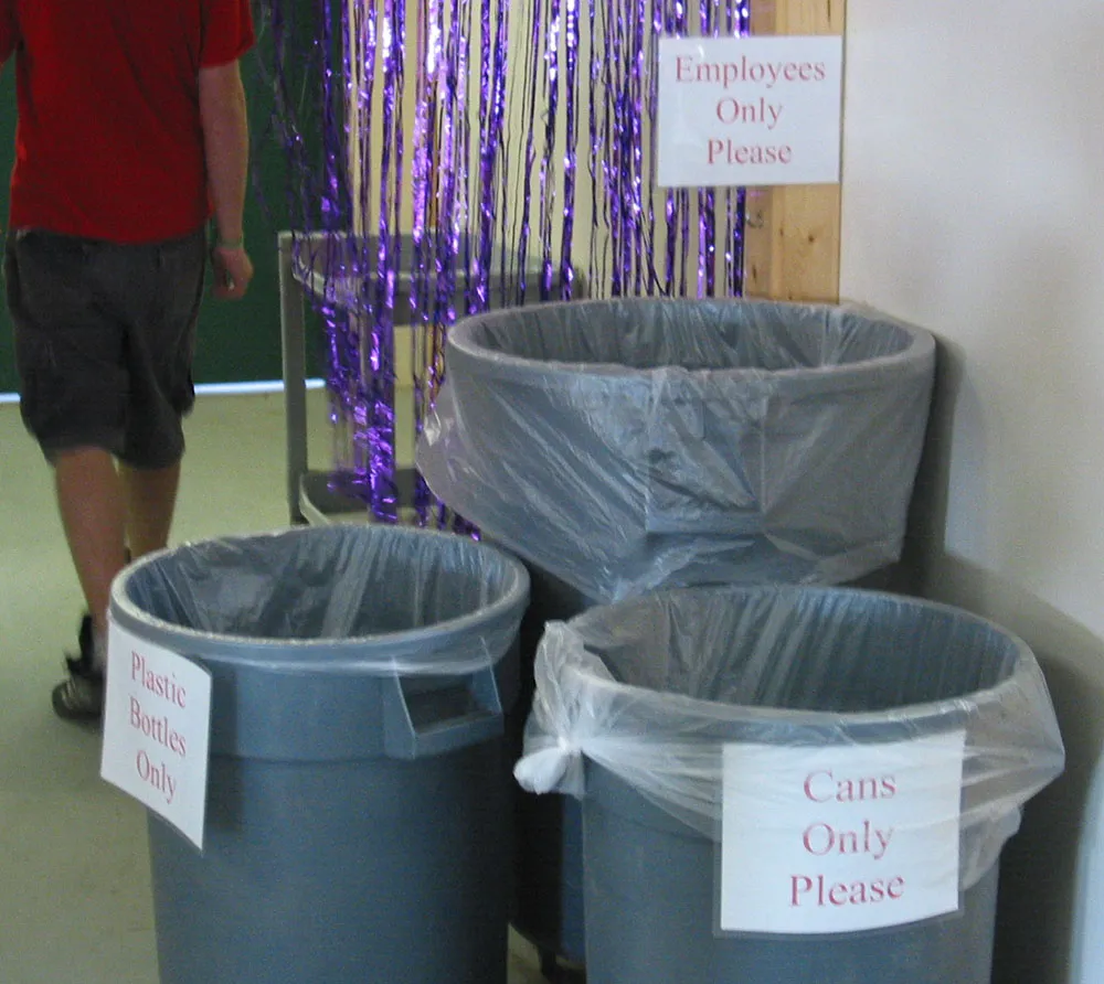 Signs on refuse cans read ‘Cans Only’, ‘Plastic Only’, and ‘Employees Only’.