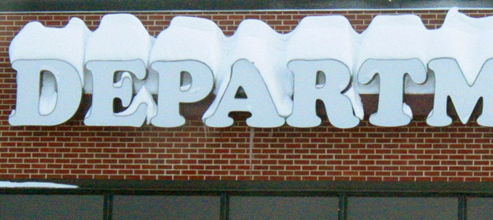 Snow-covered letters on a building.